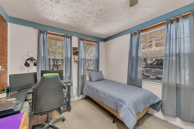 carpeted bedroom with a textured ceiling and baseboards