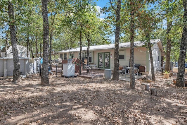 320 Pope Bnd S, Cedar Creek, TX 78612 - rear view of house featuring french doors, a wooden deck, and a metal roof