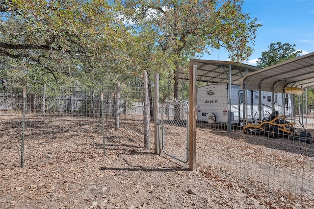view of yard featuring fence, a gate, and a carport