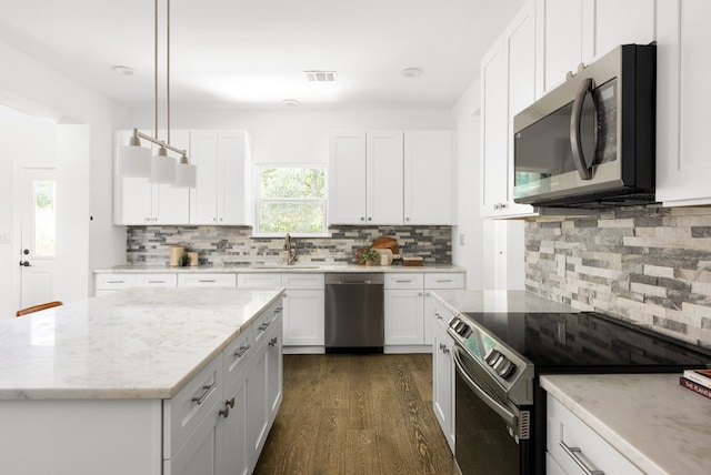 kitchen with white cabinetry, stainless steel appliances, dark wood-type flooring, and decorative light fixtures