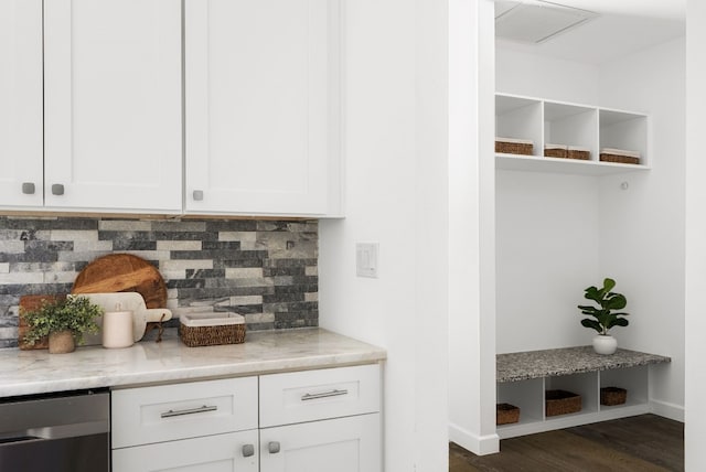 kitchen with dark wood-type flooring, light stone counters, backsplash, and white cabinets