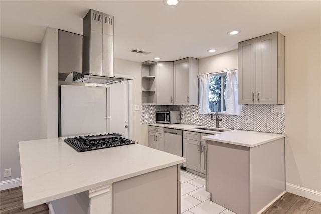 kitchen with appliances with stainless steel finishes, sink, gray cabinets, and range hood