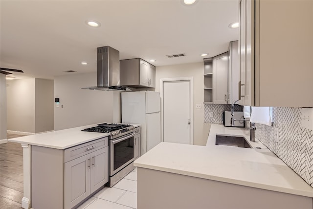 kitchen featuring gas stove, kitchen peninsula, tasteful backsplash, and ventilation hood