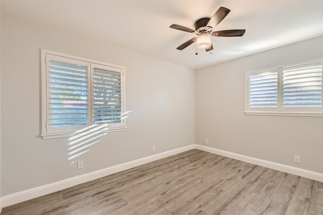 spare room with light wood-type flooring, plenty of natural light, and ceiling fan