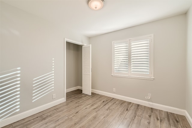 unfurnished bedroom featuring a closet and light wood-type flooring