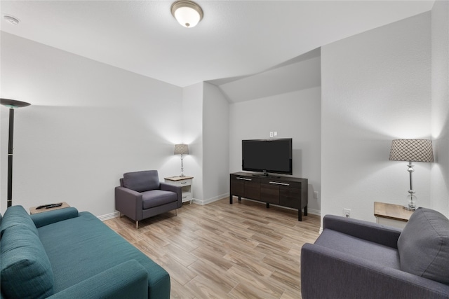 living room featuring vaulted ceiling and light hardwood / wood-style flooring