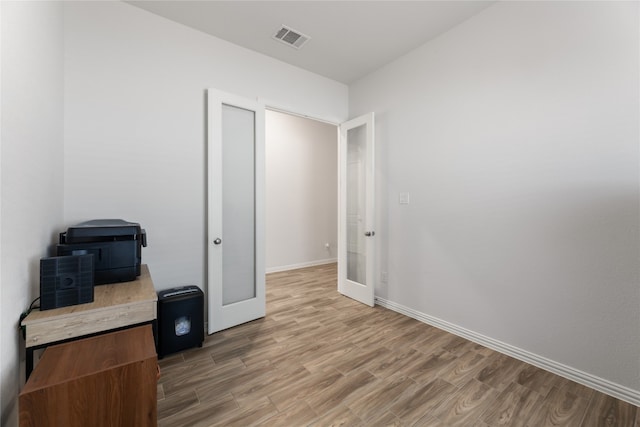 bedroom with french doors and wood-type flooring