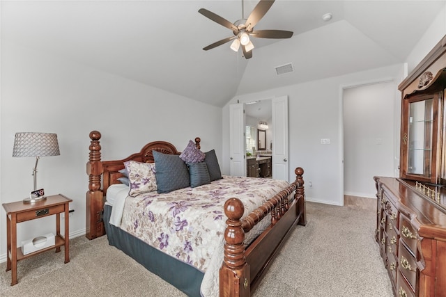 carpeted bedroom with ceiling fan, lofted ceiling, and ensuite bath