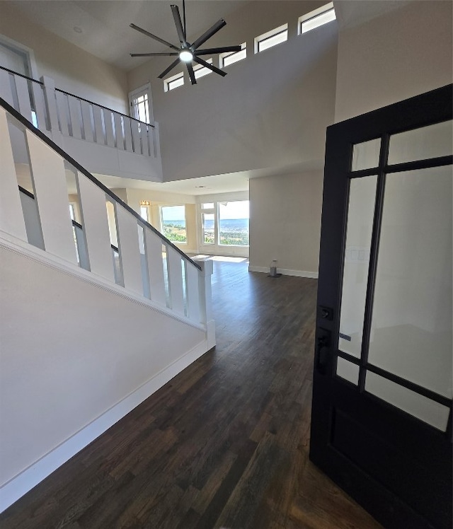 hall with a high ceiling and dark hardwood / wood-style flooring