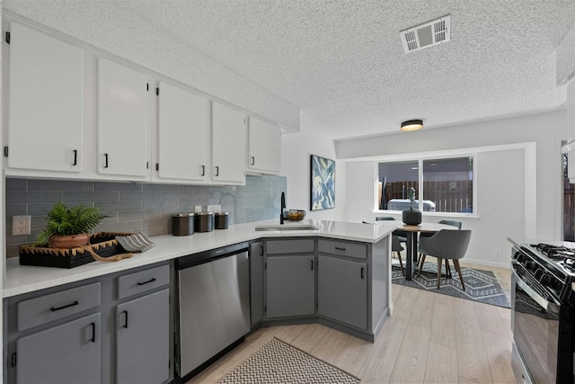 kitchen featuring black range with gas stovetop, gray cabinetry, sink, light wood-type flooring, and stainless steel dishwasher