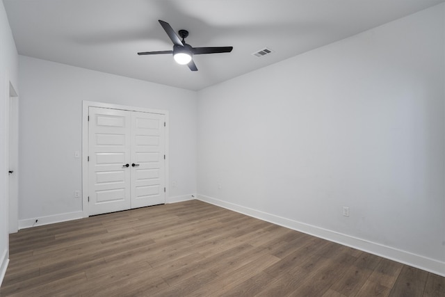 unfurnished bedroom featuring hardwood / wood-style floors, ceiling fan, and a closet