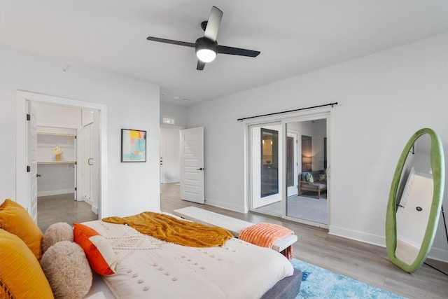 bedroom with access to outside, a walk in closet, ceiling fan, light hardwood / wood-style floors, and a closet