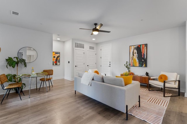 living room with wood-type flooring and ceiling fan