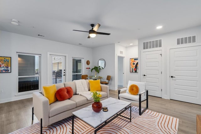 living room featuring ceiling fan and light wood-type flooring