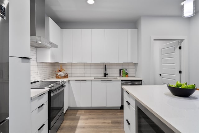 kitchen featuring white cabinetry, black electric range oven, and wall chimney range hood