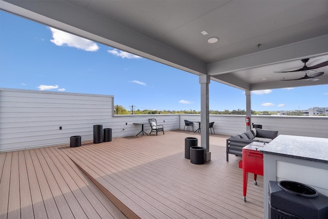 deck featuring ceiling fan and an outdoor living space