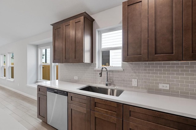 kitchen with dishwasher, dark brown cabinets, decorative backsplash, and sink