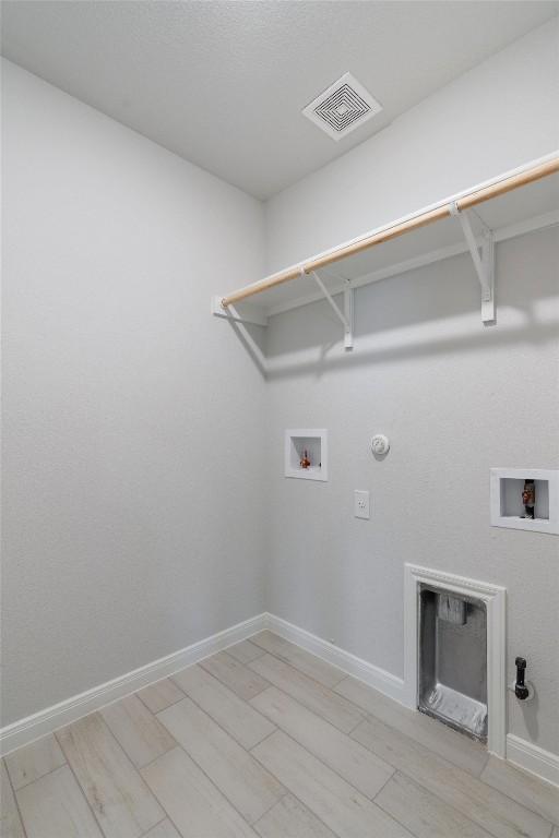 washroom with gas dryer hookup, washer hookup, and light wood-type flooring