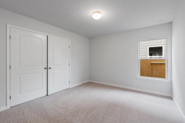 unfurnished bedroom featuring carpet flooring and a closet