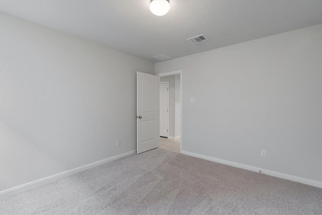 spare room featuring light colored carpet