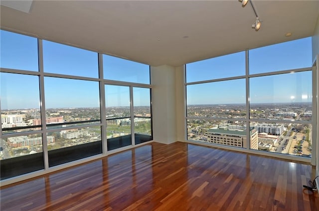 unfurnished sunroom with rail lighting