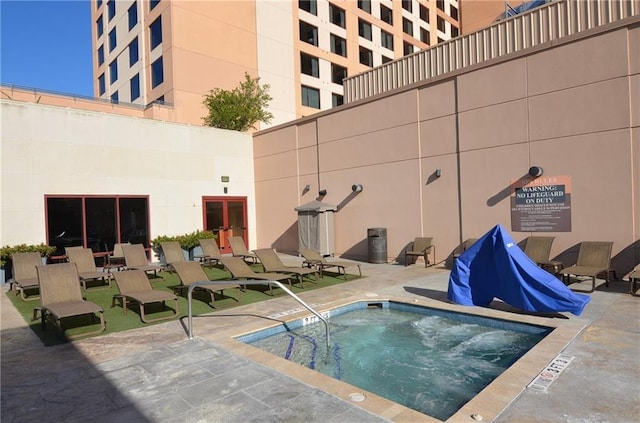 view of swimming pool with a patio and a hot tub