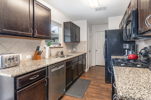 kitchen featuring dark wood-type flooring, black appliances, sink, light stone countertops, and dark brown cabinetry