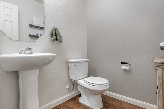 bathroom featuring sink, toilet, and hardwood / wood-style flooring