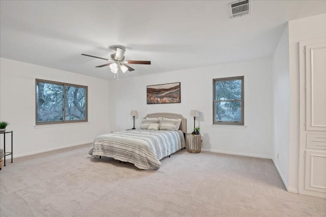 bedroom with light colored carpet, baseboards, ceiling fan, and visible vents