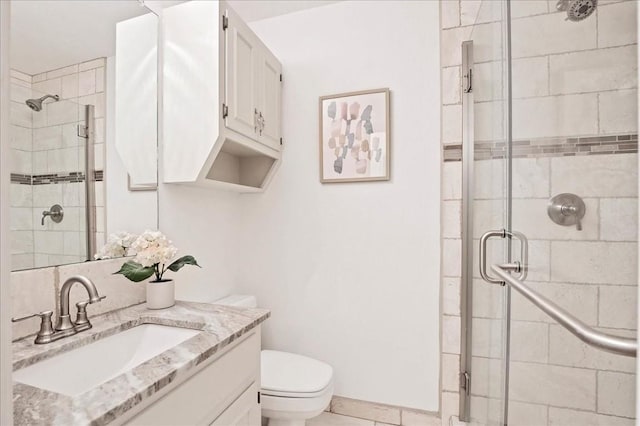 full bathroom with a shower stall, vanity, and toilet
