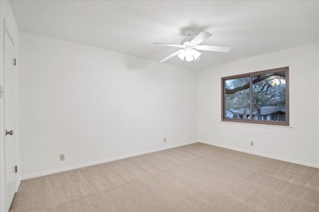 spare room with light carpet, baseboards, and ceiling fan