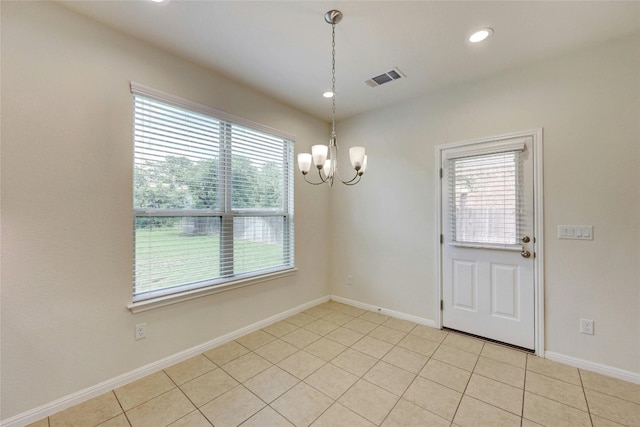 unfurnished dining area featuring a notable chandelier, a healthy amount of sunlight, and light tile patterned floors