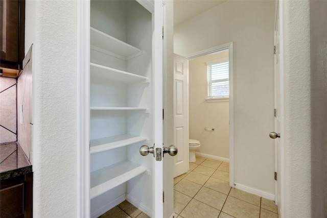 interior space with toilet and tile patterned floors