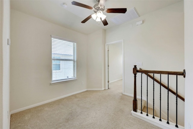 spare room featuring light colored carpet and ceiling fan