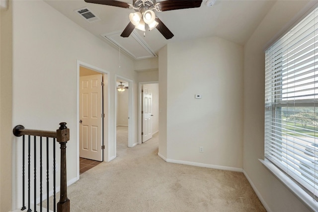 spare room featuring light carpet, vaulted ceiling, and plenty of natural light