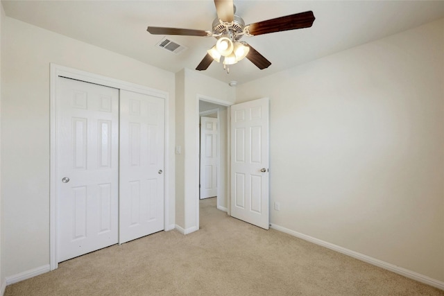 unfurnished bedroom featuring a closet, ceiling fan, and light colored carpet