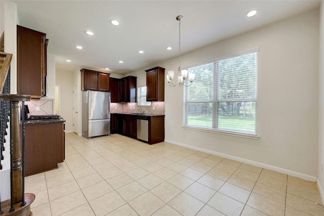 kitchen featuring backsplash, sink, light tile patterned flooring, decorative light fixtures, and appliances with stainless steel finishes