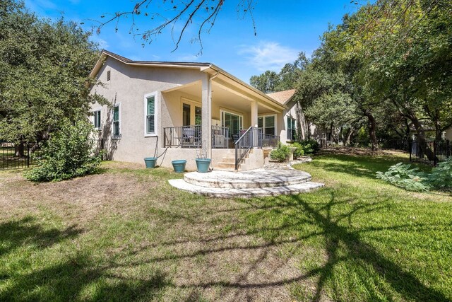 back of property with covered porch and a yard