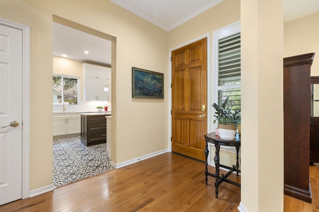 foyer featuring light hardwood / wood-style floors and crown molding