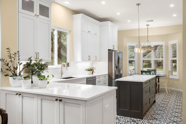 kitchen featuring appliances with stainless steel finishes, a center island, white cabinets, and sink