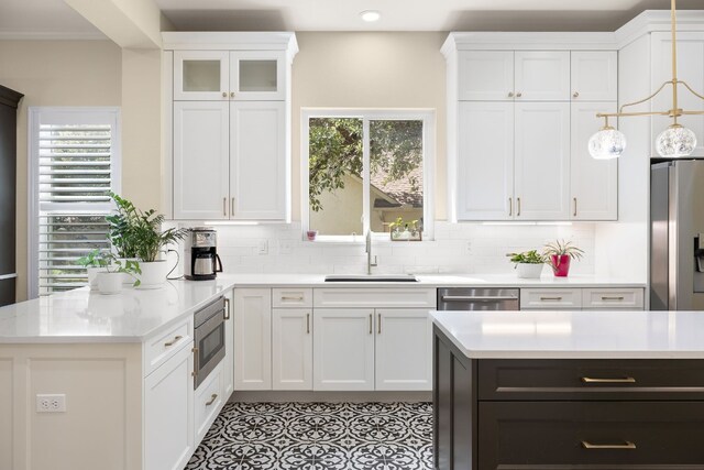 kitchen with white cabinets, a healthy amount of sunlight, stainless steel appliances, and pendant lighting