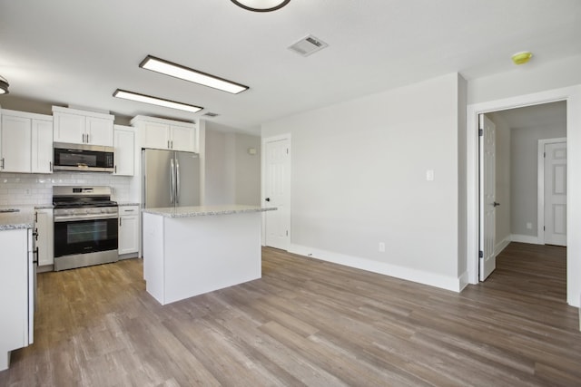 kitchen with white cabinetry, appliances with stainless steel finishes, light wood-type flooring, and a kitchen island