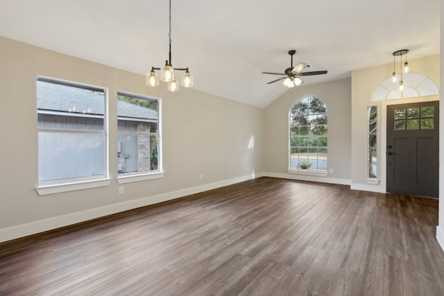 foyer featuring vaulted ceiling, a wealth of natural light, ceiling fan with notable chandelier, and dark hardwood / wood-style flooring