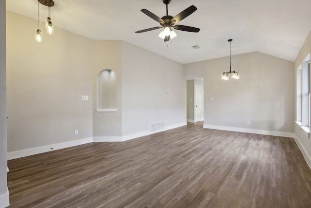 empty room with dark hardwood / wood-style floors, ceiling fan with notable chandelier, and vaulted ceiling