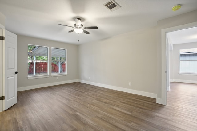 spare room featuring a textured ceiling, dark wood-type flooring, and ceiling fan