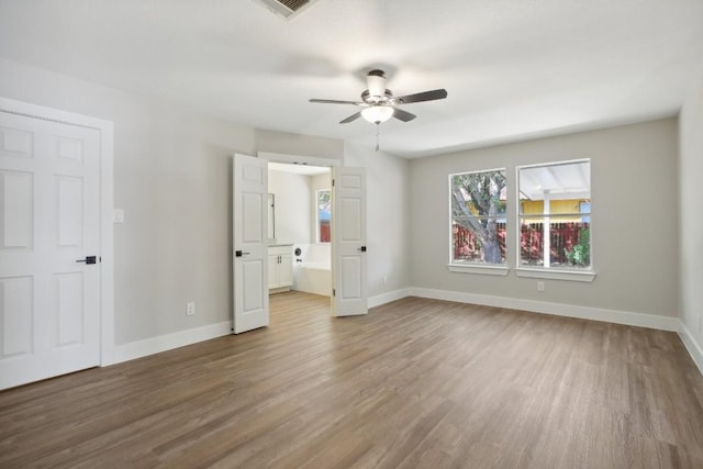 8222 Palace Pkwy, Austin, TX 78748 - unfurnished bedroom featuring wood finished floors, connected bathroom, and ceiling fan