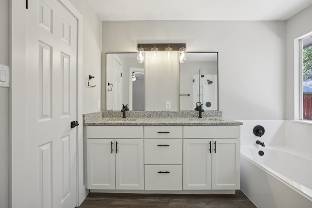 bathroom featuring vanity, hardwood / wood-style floors, and a tub