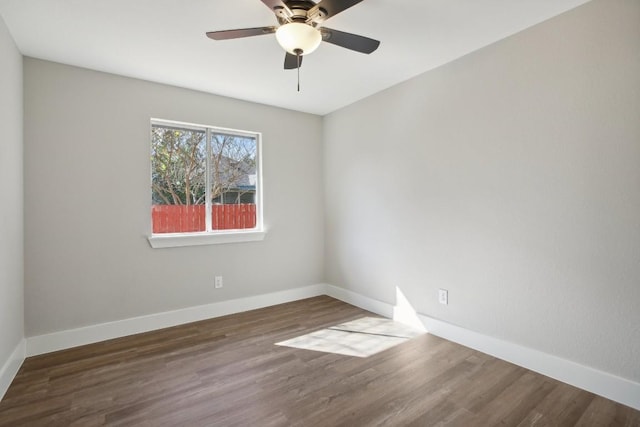 empty room featuring ceiling fan, baseboards, and wood finished floors