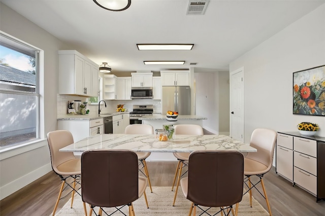 dining area with sink and wood-type flooring