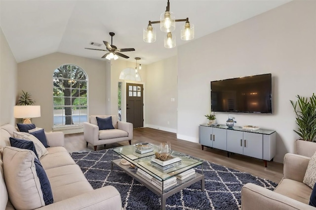 living room with ceiling fan with notable chandelier, dark hardwood / wood-style floors, and lofted ceiling